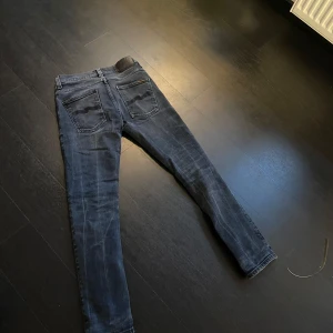 Nudie jeans W28 L30, Grim Tim - Säljer ett par mörkblå nudie jeans modell Grim Tim, W28 L30. Bra skick och sällsynt färg. Slim fit.