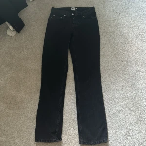 Svarta jeansbyxor från 157 - Svarta jeansbyxor från 157 med klassisk femficksdesign och raka ben. Byxorna har normal passform och stängs med dragkedja och knapp. Perfekta för en stilren och enkel look.