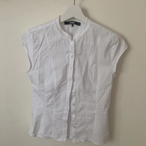Vit skjorta/blus kortärmad - Short sleeve Button-down blouse från Bikbok. I nyskick, använt den en gång den är för liten för mig. Storlek 34