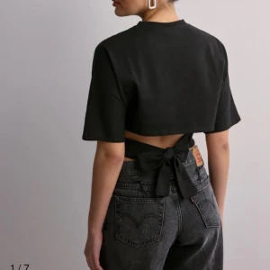 Open Back Tie Tee - Svart T-shirt topp med knytning i ryggen från Nelly. Ny med prislapp, kostar 249 på hemsidan 
