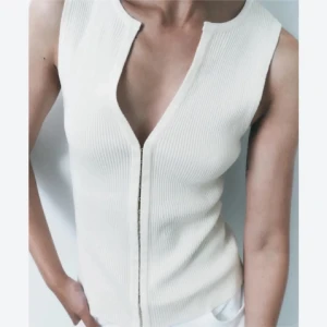 Vit ribbad linnetopp från Zara - Säljer en stilren vit ribbad linnetopp från Zara med djup v-ringning och ärmlös design. Toppen har en smickrande tight passform och är tillverkad i ett mjukt, stretchigt material. Perfekt att matcha med jeans eller kjol. Superpopulät och perfekt till sommaren!💓