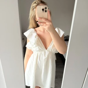 Vit volang klänning - Perfekt till studenten / midsommar! Oanvänd!! Är inte genomskinlig och är i ett bomull / linne material. Säljer för jag har hittat en annan klänning istället. (Nypris: runt 1050kr) 💞