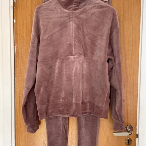 Mauve set i velour - Supersköna mjukisbyxor och tröja  i en mjuk och lyxig velourkänsla. Byxorna är i en dämpad mauve/rosa nyans och har en tight passform med hög midja. Perfekta för chill eller myskvällar hemma. Byxor i M pch tröja i S
