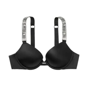 Svart bh från Victoria's Secret med logoband - Svart bh med vadderade kupor och breda axelband med Victoria's Secret-logga i vitt. Snygg och sportig design som ger bra stöd och passar perfekt under alla typer av toppar. Aldrig använd