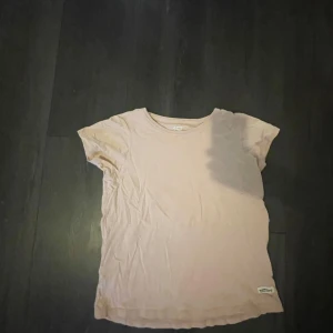 Ljusrosa t-shirt  - En enkel och stilren rosa t-shirt med rund halsringning. Perfekt basplagg att ha i garderoben. Liten lager 157 demin makers-logga nertill på ena sidan.