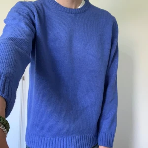 Blå stickad tröja från Zara - Säljer en blå stickad tröja från Zara med rund halsringning och ribbade muddar vid ärmslut och nederkant. Enkel och stilren modell som passar perfekt till jeans eller chinos.