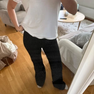 Svarta kostymbyxor med rak passform - Säljer ett par svarta kostymbyxor med rak passform och medelhög midja. Byxorna har diskret dragkedja i sidan och är sydda i ett slätt tyg som ger en stilren look. Perfekta till en snygg topp eller skjorta.