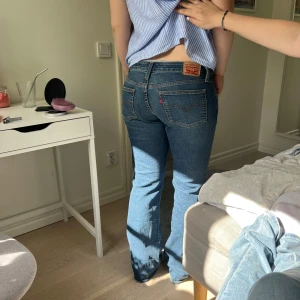 Levis lowwaist blå jeans - Klassiska blå Levis jeans med bootcut ben och normal passform. Byxorna har fem fickor, knappgylf och tydliga sömmar. Jättefina till sommaren men även våren. Tjejen på bilden är 170 och hon har endast använd dem två gånger💞