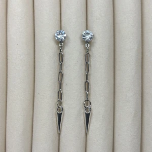 Silverfärgade örhängen med kedja och spetsig detalj - Snygga örhängen i silverfärg med gnistrande sten upptill, tunn kedja och spetsig hängande detalj. Perfekta för att ge din look en edgy touch.