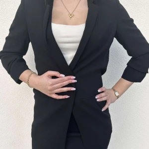 Svart Kavaj  - Superfin kavaj med trekvartsärmar, passar perfekt till finare tillfällen eller om man ska på någon fest med temat casino eller liknande. Den har ingen knapp i mitten så den är öppen om man inte håller i den. Skicket är suveränt! För referens har modellen vanligen storlek S/M eller 36/38 