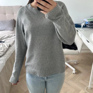 Grå stickad tröja från Vero Moda - Mysig grå stickad tröja från Vero Moda med rund halsringning och långa ärmar. Perfekt för kyligare dagar och enkel att matcha med jeans eller kjol. Klassisk och stilren design.