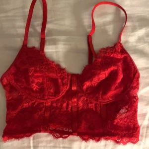 Rött spets linne - Snyggt rött spets linne med justerbara axelband och vacker spetsdetalj. Perfekt för att lägga till en touch av elegans och stil.❤️