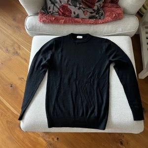 Svart tröja från John Henric - Säljer en stilren svart tröja från John Henric. Tröjan har en klassisk design med långa ärmar och rund halsringning. Perfekt för en elegant och enkel look.