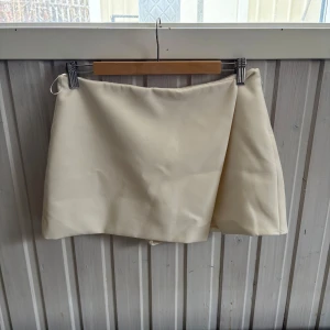 Cremevit kjol ZARA - Använd fåtal gånger. Inbyggda shorts. Strl L men är mer som en M.