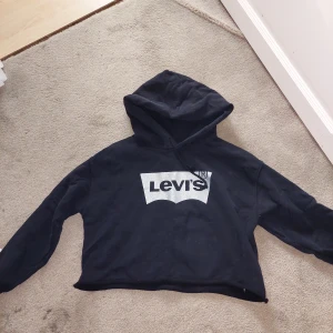 Kort Levi's hoodie med glittrig logga - Svart magtröja/croptop hoodie från Levi's med glittrig silverlogga