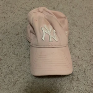 Rosa keps med broderad logga - Snygg rosa barn keps med vit broderad logga framtill. Perfekt för en avslappnad stil. Justerbar passform för bekvämlighet.