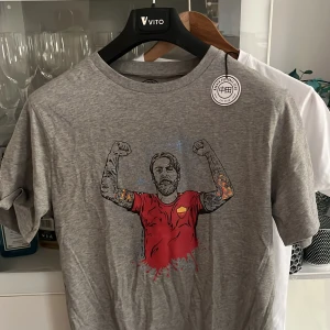 T-shirts med tryck från Nakata (ej använda) - Två t-shirts från Nakata med unika tryck. Den gråa har ett motiv av De-rossi med tatuerade armar i röd tröja. Den vita har en illustration av Totti. Perfekta för dig som gillar stilrena och sportiga motiv. Paketpris  :400 annars 249
