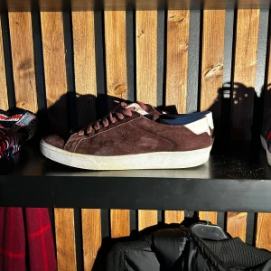 Vinröda sneakers i mocka - Snygga vinröda  sneakers i mocka ifrån Yves saint Laurent med vit sula och matchande snörning. Perfekta för en stilren look. Box ,extra snören, osv tillkommer