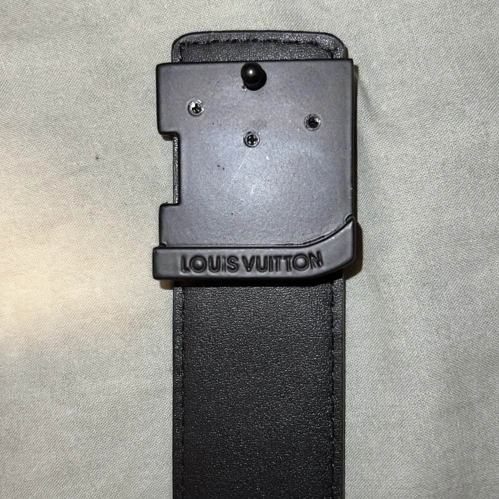 Snyggt svart bälte med präglad logotyp och monogramdetaljer. Bältet har ett stilrent spänne med logotypen i svart metall. Perfekt för att ge en lyxig touch till din outfit. Detta bälte är helt nytt och har används 2 gånger.. Asusteet.