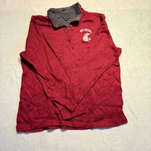 Champion collage half zip - Champion collage tröja med WSU Cougars-logga på bröstet. Half zip med en mjuk, fodrad krage i grått. Perfekt för kyliga dagar!