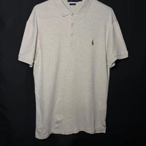 Ralph Lauren piké | Beige/Cremefärgad| Slim Fit | Stl M - Läs nedan för mer info!😊  Säljer en stilren beige pikétröja från Ralph Lauren. Tröjan har en klassisk krage med knappar och det ikoniska broderade logotypen på bröstet. Perfekt för en avslappnad men ändå elegant look.  Produktinformation:  ✅ Märke: Ralph Lauren  ✅ Storlek: M  ✅ Färg: Beige/Cremefärgad ✅ Material: Bomull ✅ Passform: Slim fit – perfekt att styla med jeans eller chinos. ✅ Skick: Mycket bra skick, knappt använd  Frakt och betalning: 📦 Snabb leverans – skickar inom 1-2 dagar📦