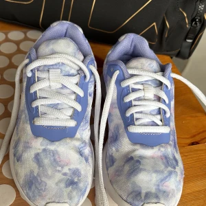 Blå och vita sneakers med mönster - Snygga sneakers i blått och vitt med ett unikt mönster. Skorna har vita snören och en bekväm sula. Perfekta för en cool och avslappnad stil.