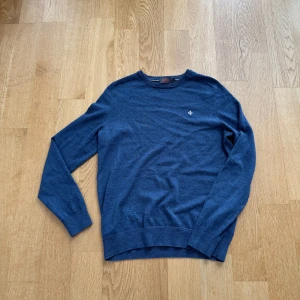 Tröja i merino från Morris - Säljer en stilren blå tröja från Morris i merinoull. Tröjan har en liten broderad detalj på bröstet och långa armar. Den är storlek L men skulle själv säga att den passar M mer och är perfekt för mig som är 180.