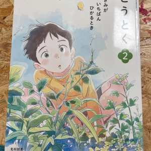 Illustrerad barnbok på japanska - Denna bok är en illustrerad barnbok på japanska med färgglada teckningar och serierutor. Omslaget visar en pojke i en trädgård med växter och fjärilar. Boken innehåller både text och bilder som verkar rikta sig till yngre läsare.
