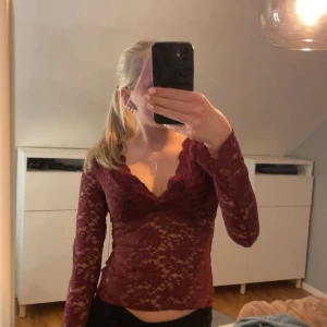 Vinröd spetsblus - Säljer en super fin vinröd spetsblus med v-ringning och långa ärmar. Blusen är genomskinlig och i nyskick💗