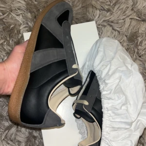 Maison Margiela skor - Sjuka Maison margiela gats i en unik svart coffe färg!  Skick: 10/10🧮 Inkluderat: Box, 2 Dustbags, Skor, kort♦️ Pris: 3999🎗️ Storlek: 43♣️ Snabbaffär = priset sänks-SERIÖSA BUD🔓 ‼️OBS sulan är ljusare det är bara ljuset i bilden!