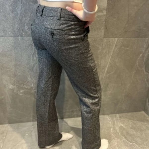 Grå kostymbyxor - Snygga grå kostymbyxor med normal passform och raka ben. Byxorna har en klassisk design med knappar och hällor för bälte. Perfekta för en stilren look.