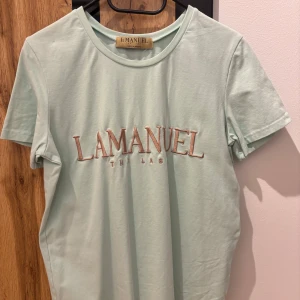 Mintgrön t-shirt från La Manuel - Snygg mintgrön t-shirt från La Manuel med broderad text på framsidan. Perfekt för en avslappnad stil. Tillverkad i mjukt material för extra komfort.