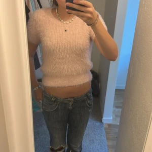 Rosa fluffig tröja - Säljer en supermjuk och fluffig rosa tröja med korta ärmar. Perfekt för en mysig dag eller en utekväll. Tröjan har en tight passform och är gjord av ett syntetmaterial som känns lyxigt mot huden.