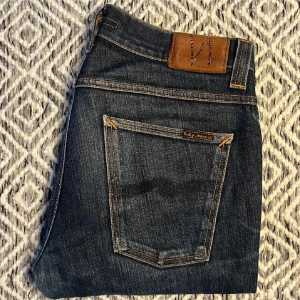 Nudie jeans grim tim - Fina grim Tim jeans! Storlek 33/32 sitter skitbra och är i fint skick mini hål fickan 