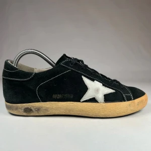 Golden Goose Superstar - Snygga svarta sneakers från Golden Goose. Säljer nu dessa sköningar inför sommaren. De är i storlek 38 men passar även 39. Nypris runt 5000 hos mig 2599 kr. Vid frågor eller funderingar hör av dig! Vid snabb affär skickar jag med en mystery gift. Självklart äkta!