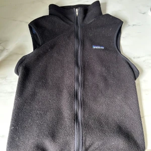 Patagonia väst - Säljer en svart fleeceväst från Patagonia. OBS - den har lite pälshår på sig men går att få bort enkelt. Kom med förslag så kan vi förhandla