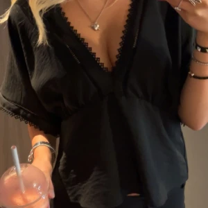 Svart blus med spetsdetaljer - Snygg svart blus med v-ringning och spetsdetaljer. Den är knappt använd, köpt på Zara i somras 