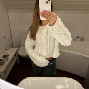 Vit stickad tröja med öppen rygg - Säljer en superfin vit stickad tröja med öppen rygg. Den är perfekt för både höst och vinter och har en mysig känsla. Tröjan är långärmad och har ett snyggt mönster som ger den lite extra stil. Passar perfekt till både jeans och kjol!