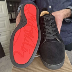 Svarta sneakers från Christian Louboutin - Snygga svarta sneakers i mocka från Christian Louboutin med den röda sulan. Skorna har snörning och en rund tå, Pris kan diskuteras, tveka ej att skriva om ni har några frågor eller vill se mera bilder!