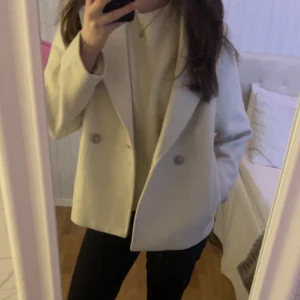 Vit kappa  - Säljer en vit/beige kappa från hm i storlek m. Den passar bra till våren och hösten 🌸🍁 Tyvärr så har den ett litet hål på insidan av kappan men det syns knappast. 💕💕 