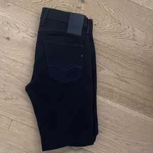 Svarta jeansbyxor från Replay - Snygga svarta jeansbyxor från Replay. Byxorna har en normal passform och är tillverkade i ett slitstarkt material. Perfekta för en stilren look. Det är storlek W31 L32. Hör gärna av dig vid frågor eller funderingar! Mvh Melker