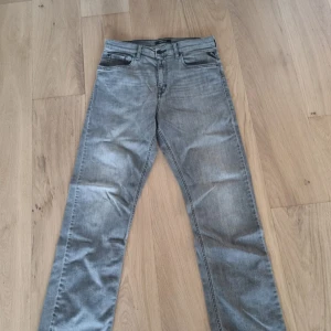 Grå jeans från Replay - Säljer ett par grå jeans från Replay. De har en klassisk femficksdesign och en rak passform. Perfekta för en avslappnad stil.