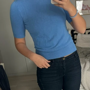 Blå stickad T-shirt - Säljer en jättefin blå stickad t-shirt, färgen är som bild 2