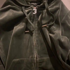 Mörkblå och mörkgrön velourjacka från Juicy Couture - Säljer en snygg mörkblå och mörkgrön velourjacka från Juicy Couture med dragkedja och huva. Aldrig använda och jätte fina priset kan diskuteras.