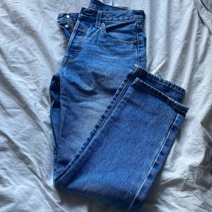 Blå jeans från Levis - Säljer ett par klassiska blå Levis jeans med fem fickor och knappgylf. De har en snygg, tidlös design och är perfekta för alla tillfällen. Märkeslappen syns tydligt på baksidan. Använda 3 gånger. 