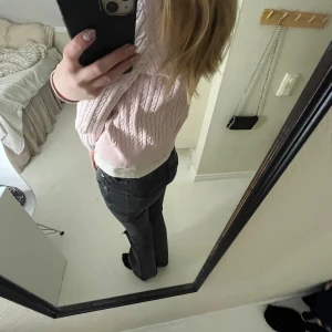 Rosa kabelstickad kofta från Ralph Lauren - Säljer en söt rosa kabelstickad kofta från Ralph Lauren. Koftan har långa ärmar och knappar framtill, perfekt för en stilren look. Den är gjord i ett mjukt material som känns skönt mot huden. Passar bra till både jeans och kjol.💗 