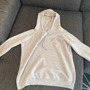 Grå hoodie - Säljer en stilren grå hoodie med långa ärmar och justerbar huva. Perfekt för en avslappnad look. Passar bra till både jeans och träningsbyxor. Obs lite i storlek.👍🏻