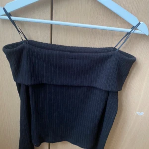 Svart ribbad tubtopp från Stradivarius - Säljer en off shoulder topp från berskha. Helt oanvänd och köpt för 300