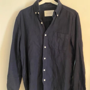 Mörkblå skjorta A Days March - Snygg mörkblå skjorta från A Days March med klassisk krage och vita knappar. Skjortan har en bröstficka och långa ärmar, perfekt för en stilren look. Passar bra till både jeans och chinos.