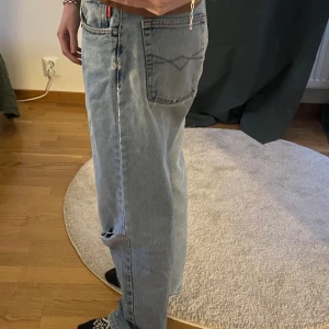 Jeans  - Snygga blå jeans med en klassisk, vintage design. De har en rak passform. Byxorna har en mellan midja och några hål vid knäna. Påminner om levis men är ifrån jack davys. 